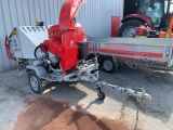 a small red machine that is parked in front of a building