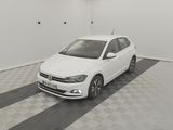 the white volkswagen polo is parked in the garage of a building