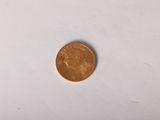 une petite pièce de monnaie posée sur une surface blanche, avec un fond blanc