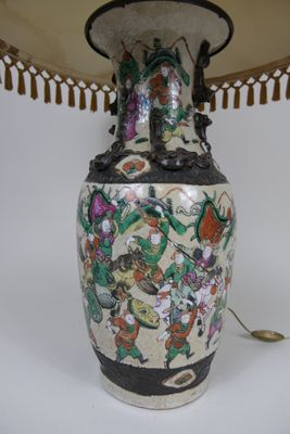 a large vase with a lamp on a white table