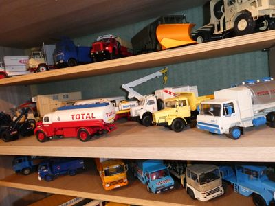 many different types of toy trucks on a shelf