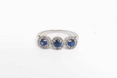 une bague en or blanc sertie de trois saphirs et de diamants