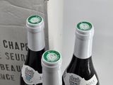 two bottles of wine sitting next to each other on a table