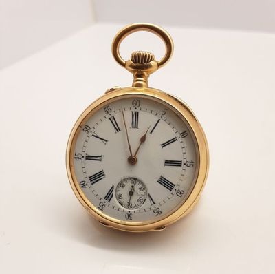 une montre de poche en or avec des chiffres romains sur le cadran