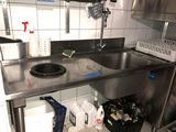un évier en inox dans une cuisine où le plan de travail est encombré