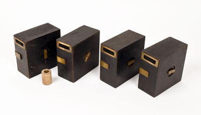 quatre morceaux de bois noir ornés de bordures dorées et comportant un petit trou au milieu