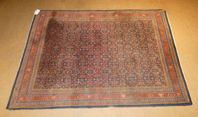 un vieux tapis posé par terre, sur lequel est accrochée une étiquette