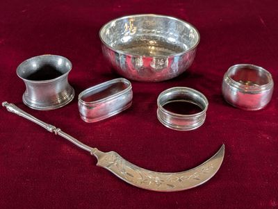 de nombreux objets en argent posés sur un tissu rouge