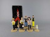 several figurines of people standing in front of a cell phone