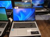 Plusieurs ordinateurs portables sont exposés dans un magasin, avec leurs étiquettes de prix.