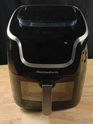 une friteuse à air chaud posée sur une table en bois, à côté d'un couteau