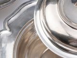 a silver plate with a lid on a white table