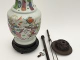 a white vase with a painting on it next to a pair of scissors