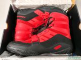 a pair of red and black snow boots in a box