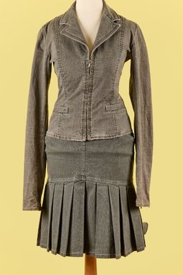 une veste en jean et une jupe plissée présentées sur un mannequin