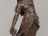 bronze statue of a woman holding a bowl and a dog on a table