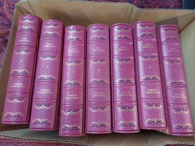 plusieurs livres roses dans une boîte en carton posée sur une table