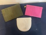 three different colors of purses on a blue surface