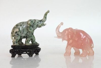 deux figurines d'éléphants placées côte à côte sur une surface blanche