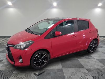 une Toyota Yaris rouge garée sur un sol à damier
