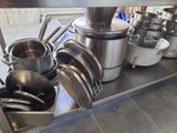 many pots and pans sitting on a shelf in the kitchen
