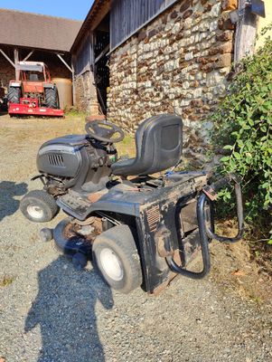 a lawn mower parked in front of a building