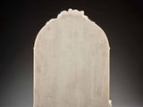a white marble tombstone with a carved top on a black background