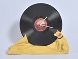 une horloge sur laquelle sont posés un disque vinyle et une figurine de chien