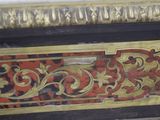 a close up of a gold and red painting on a wall