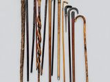 a group of old canes and cane sticks on a white surface