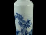 un vase bleu et blanc posé sur une surface noire