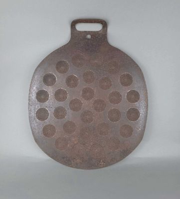 un gros objet métallique percé de trous