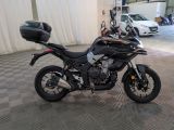 a black motorcycle parked in a garage with a helmet on top of it