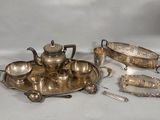 a silver plate with a teapot, spoon, and other items on it