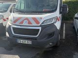 une camionnette blanche garée dans un parking à côté d'autres voitures