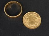 un gros plan d'une pièce de monnaie et d'une bague sur une surface noire
