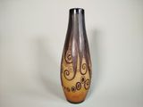 un vase marron et noir orné de motifs en spirale