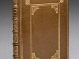 un livre en cuir marron avec des finitions dorées et une bordure dorée