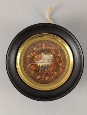 une assiette noire et dorée sur laquelle figure une image