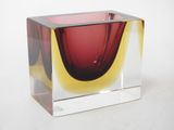 a glass vase with a red and yellow design on it