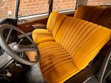 a yellow seat in the back of a car with a steering wheel