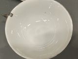 a white bowl sitting on top of a table next to a remote control