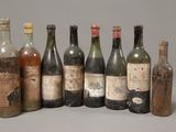 six bottles of wine are lined up in a row on a table