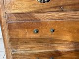 a wooden chest of drawers on a tile floor