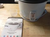 a crock pot sitting on a table next to a cookbook