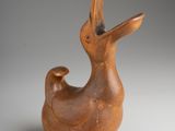 a brown bird shaped vase sitting on top of a table