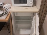 un micro-ondes blanc posé sur un petit meuble