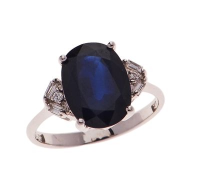 a close up of a ring with a blue stone and diamonds