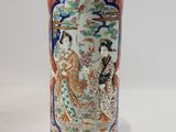 a vase with a painting on it sitting on a table