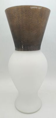 un vase blanc surmonté d'un couvercle marron, posé sur une table